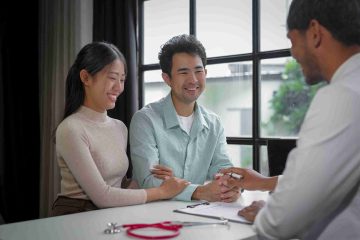 Asian couple visiting an STD clinic and speaking with a doctor.